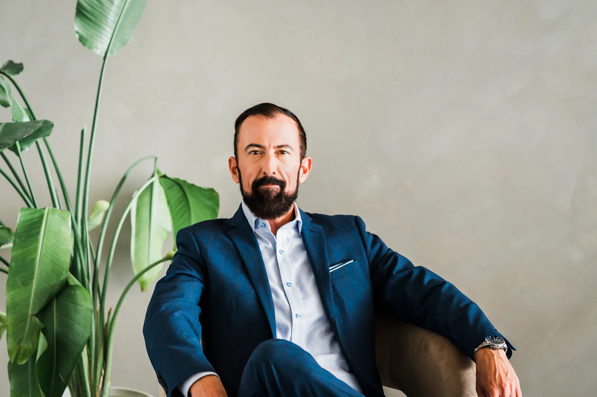 Raymond seated in a blue suit